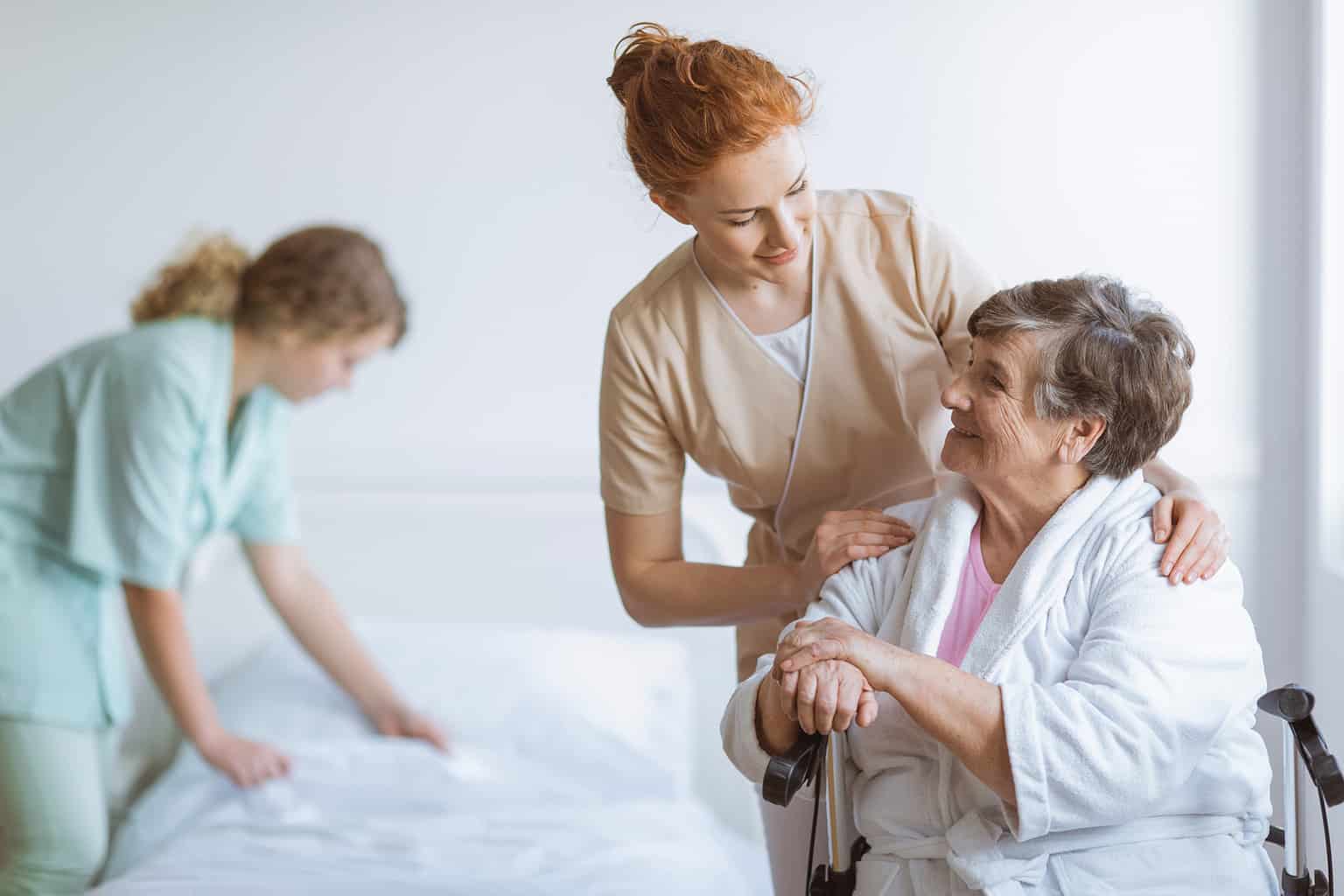 Nurses assisting older woman